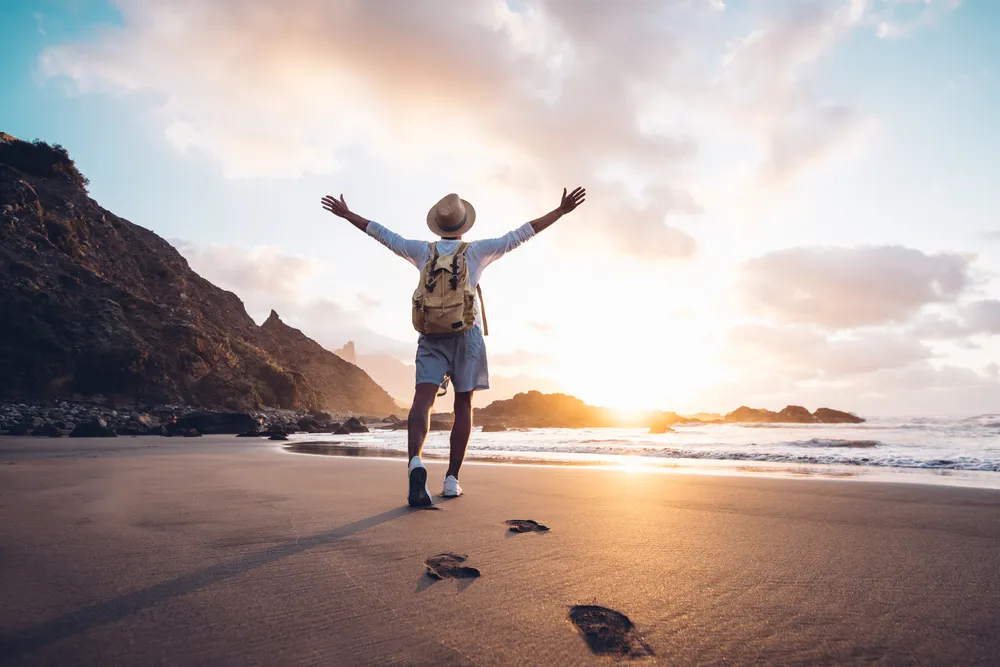 A traveller on a quiet island beach at sunset